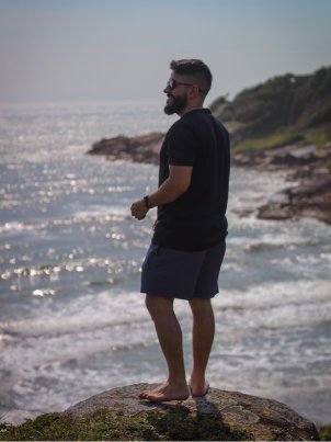 Cleiton Avi em cima de uma pedra com o mar ao fundo