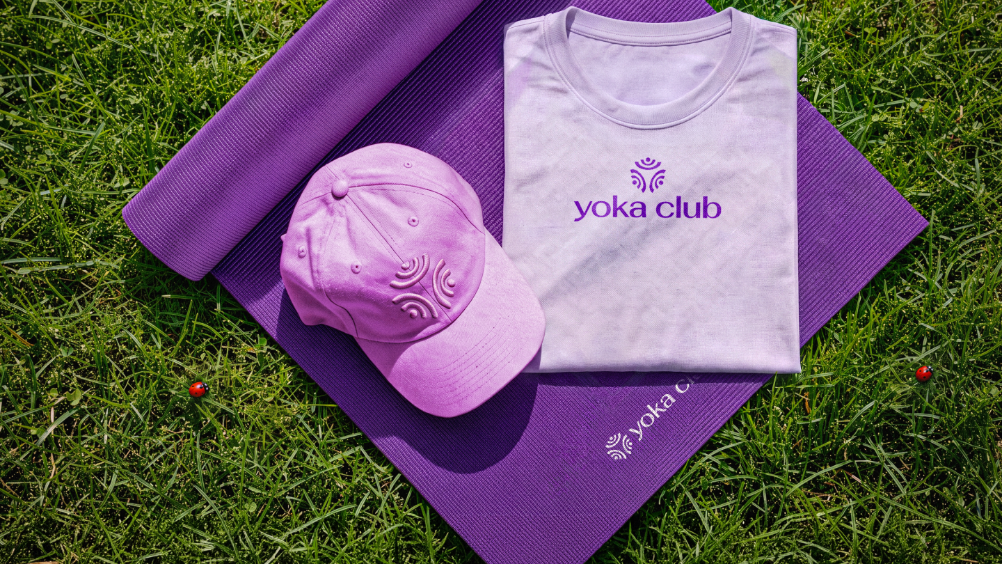 Logo Yoka Club aplicado em um boné, camiseta e tapete de yoga.