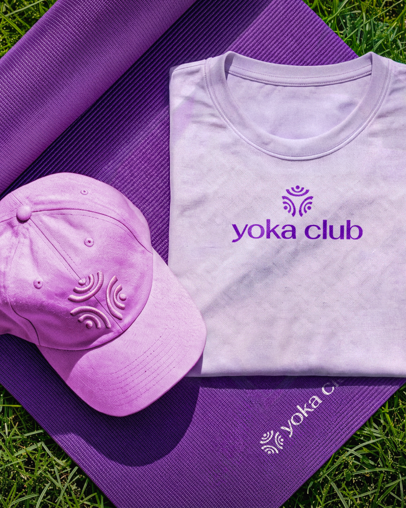 Logo Yoka Club aplicado em camiseta, boné e tapete de yoga.